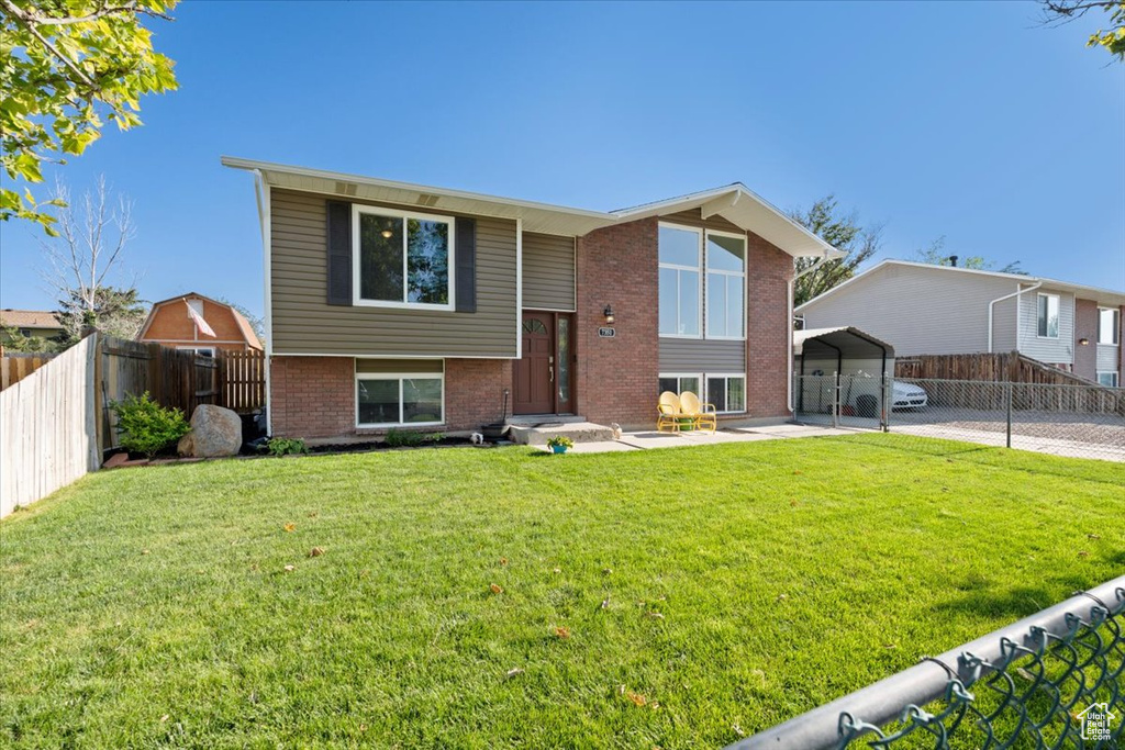 Raised ranch featuring a detached carport and brick siding