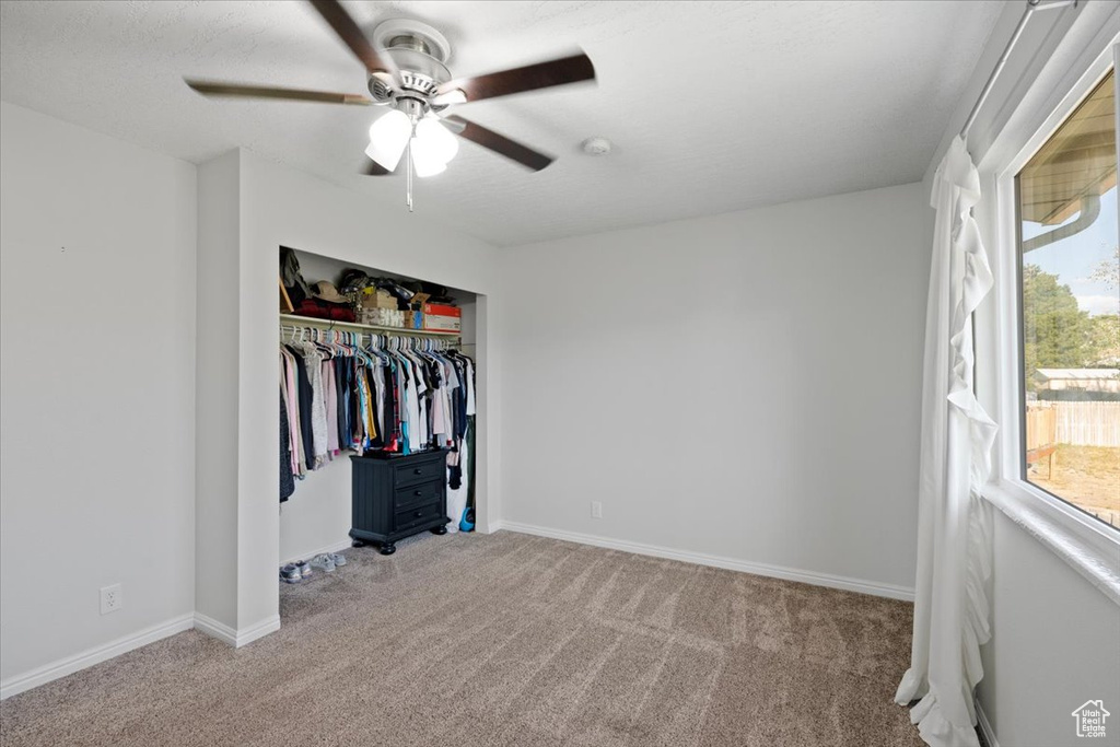 Unfurnished bedroom with light colored carpet, a closet, and ceiling fan