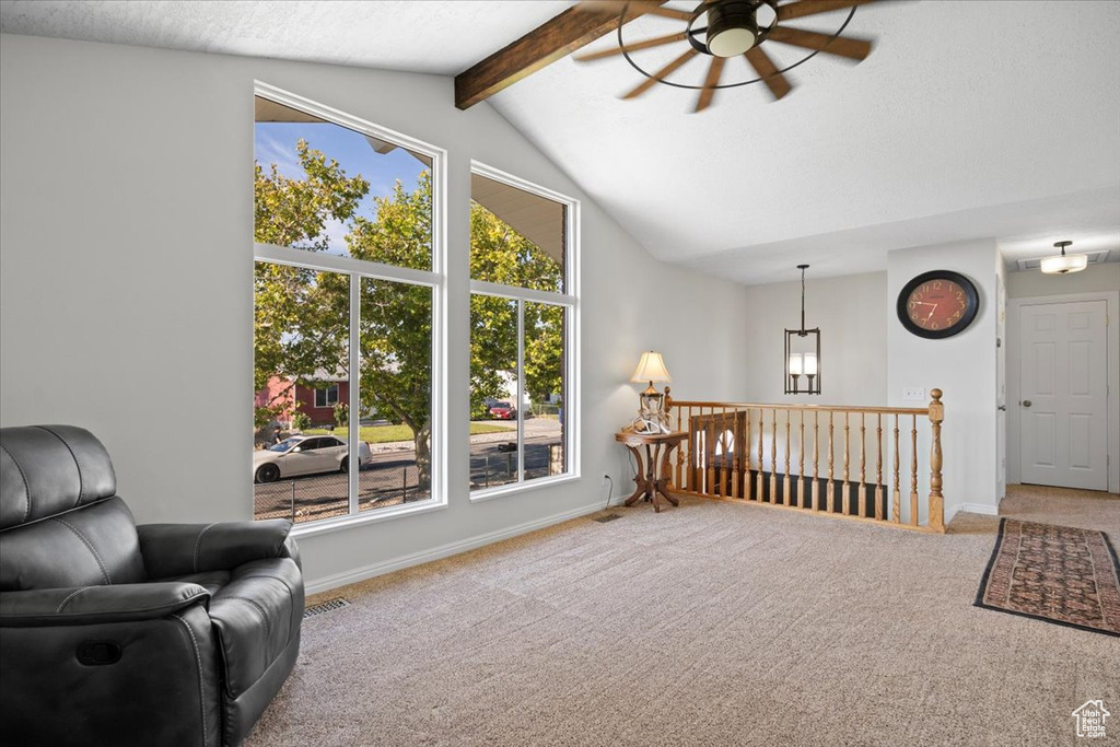 Living area featuring ceiling fan, carpet flooring, and an upstairs landing