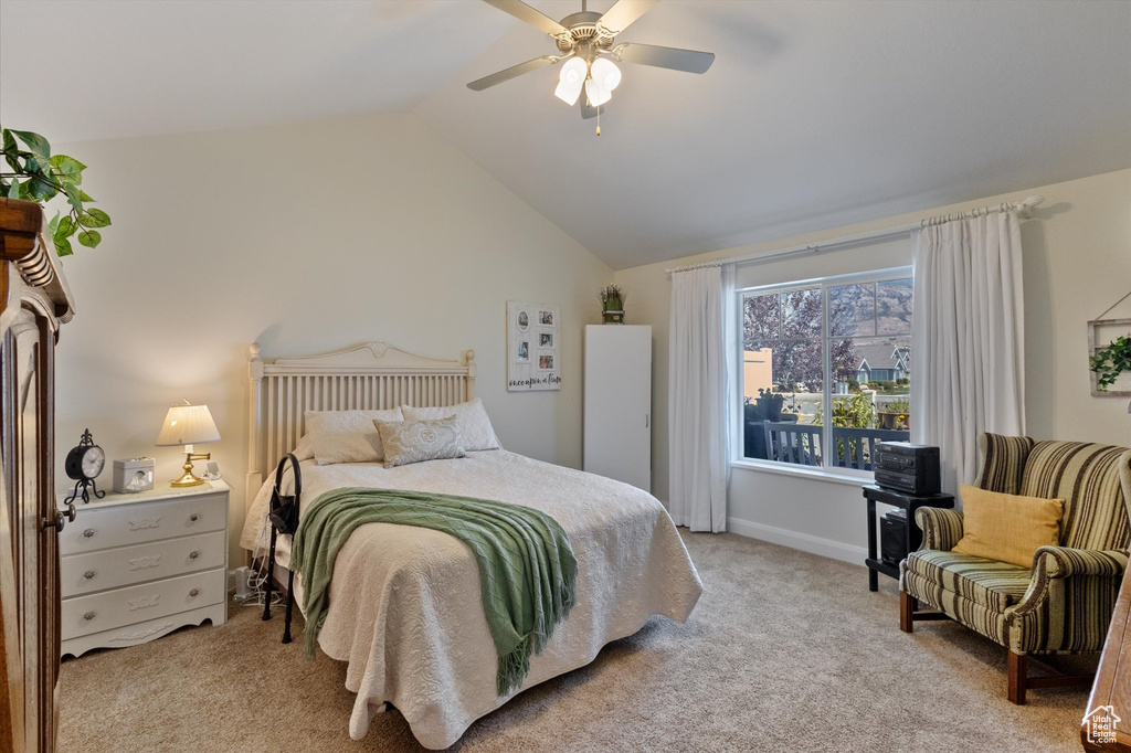 Bedroom featuring light carpet, lofted ceiling, and a ceiling fan