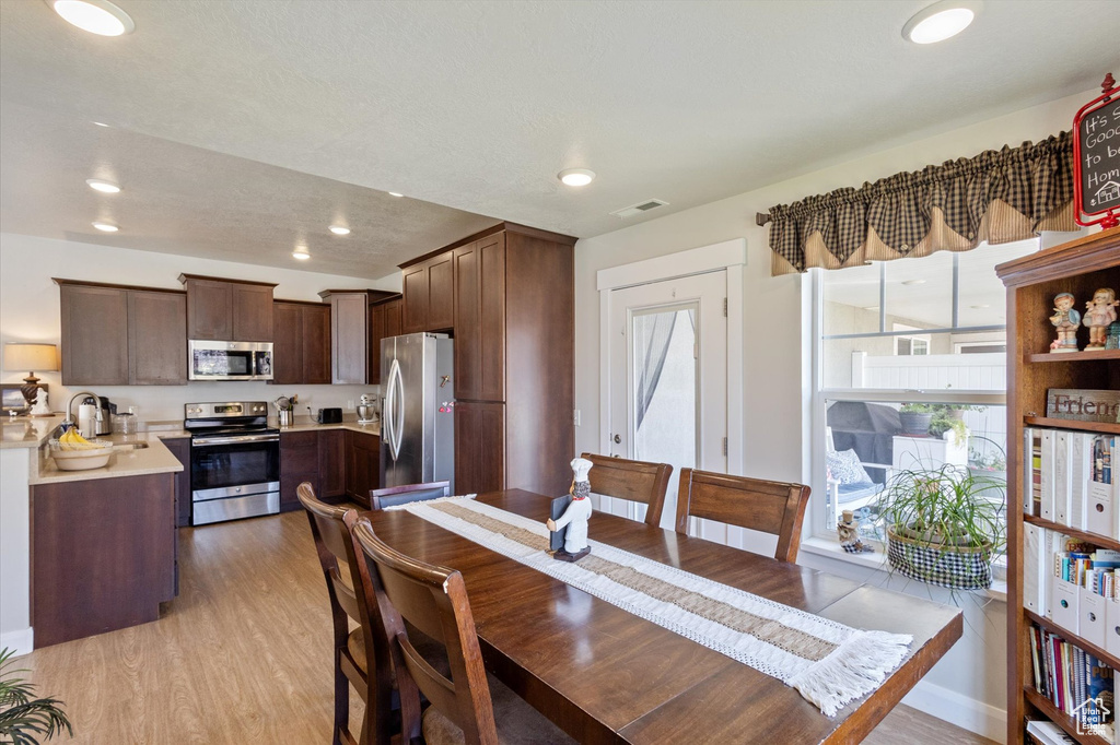 Dining area with wood finished floors and recessed lighting