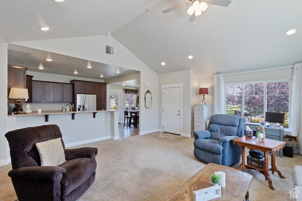 Living room with light carpet, recessed lighting, ceiling fan, and high vaulted ceiling