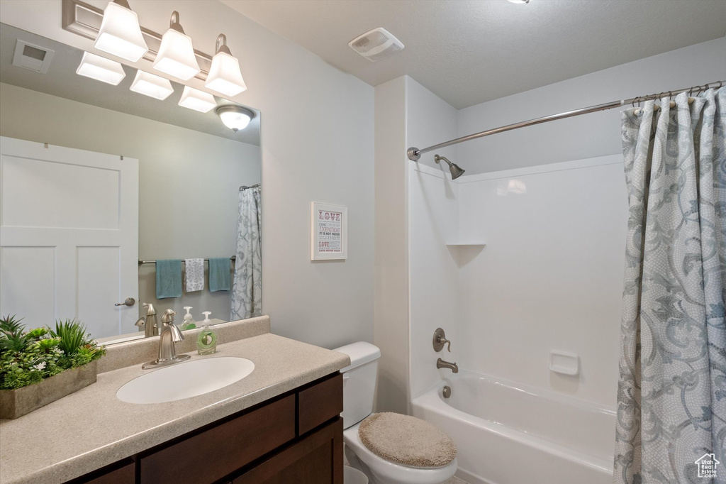 Bathroom featuring shower / bath combo with shower curtain and vanity