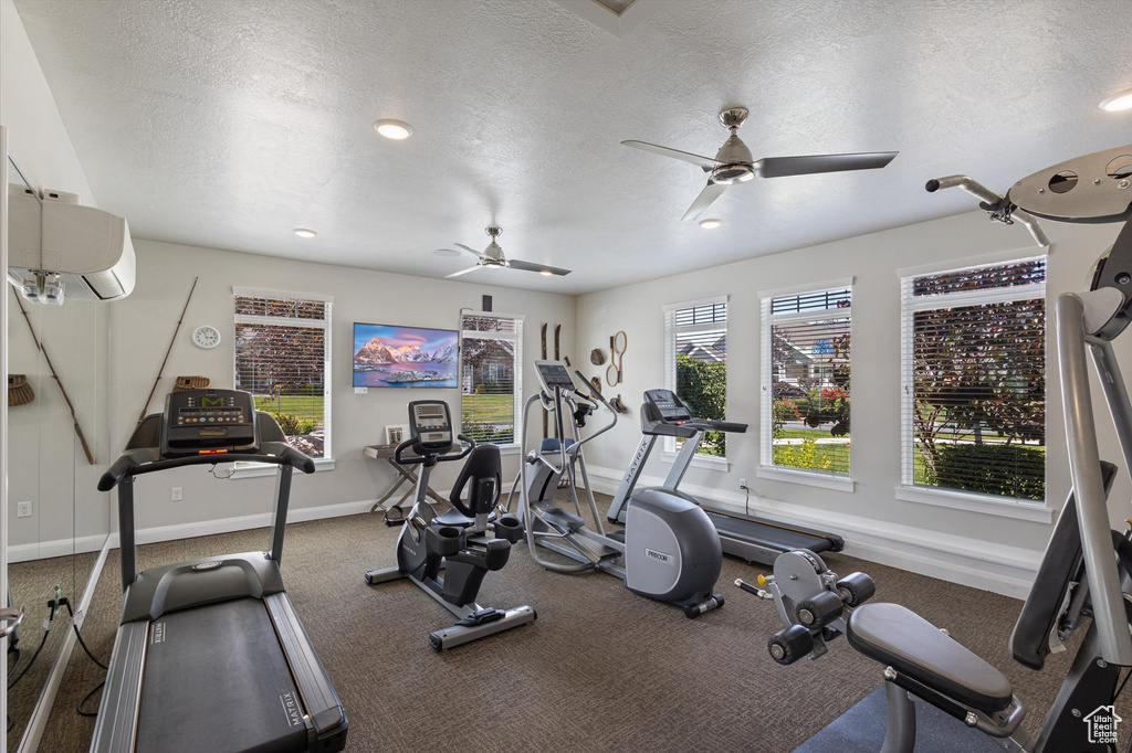 Exercise room featuring a ceiling fan, a textured ceiling, carpet, recessed lighting, and a wall unit AC