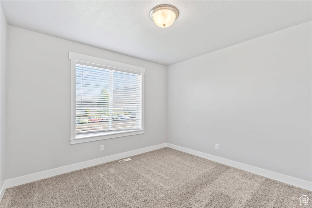 Carpeted empty room featuring baseboards