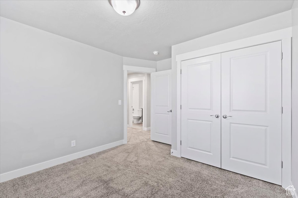 Unfurnished bedroom with carpet and a closet