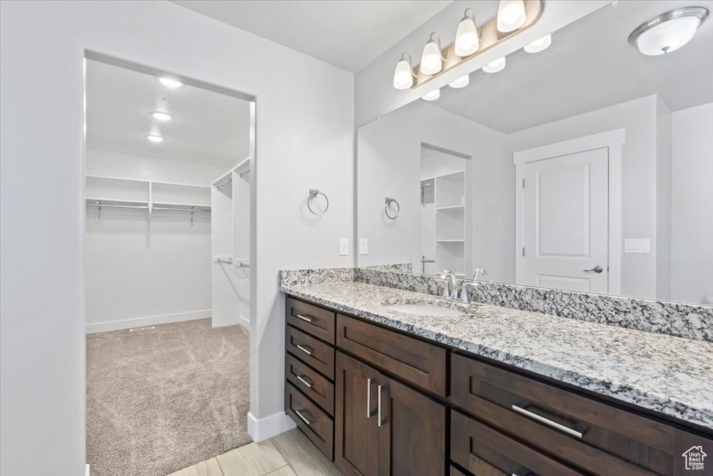Full bathroom featuring vanity and a walk in closet