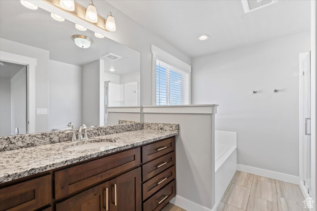 Full bath with vanity and a garden tub