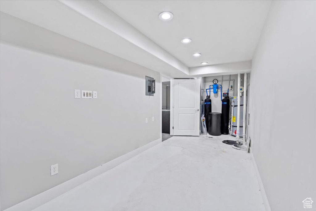Basement featuring recessed lighting, electric panel, a water softener, and strapped water heater