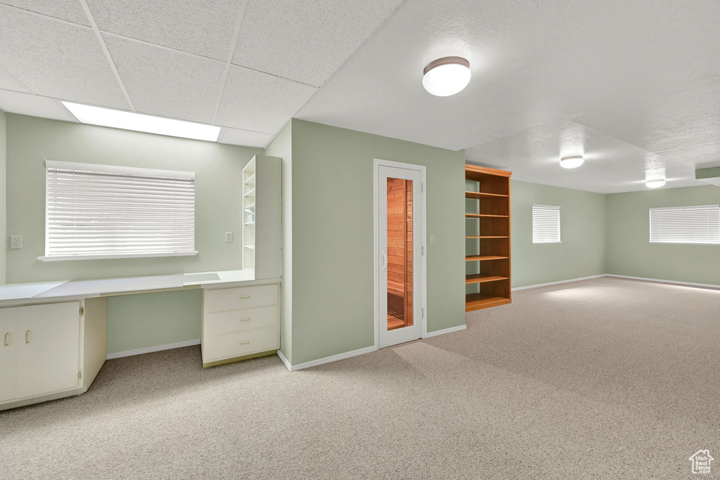Basement featuring light colored carpet and an office area