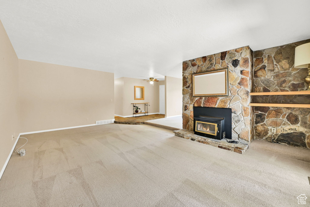Unfurnished living room with carpet and a ceiling fan
