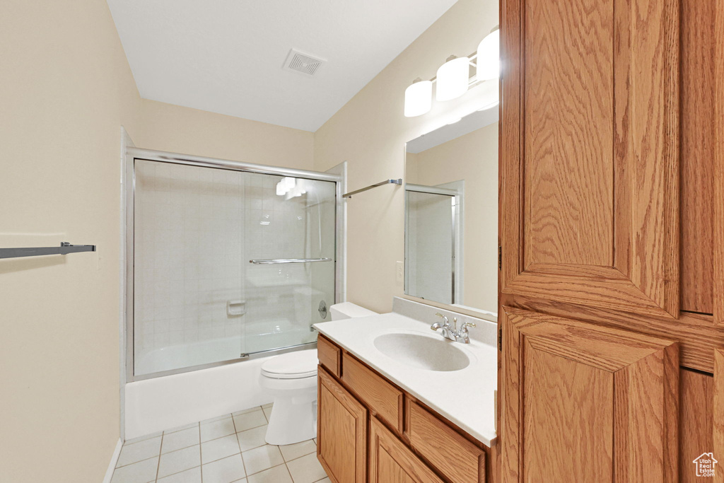 Bathroom with vanity, tile patterned floors, and bath / shower combo with glass door
