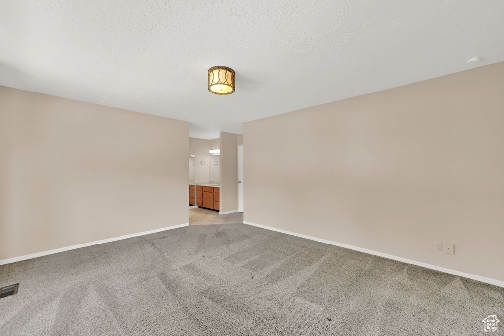 Empty room with light carpet and baseboards