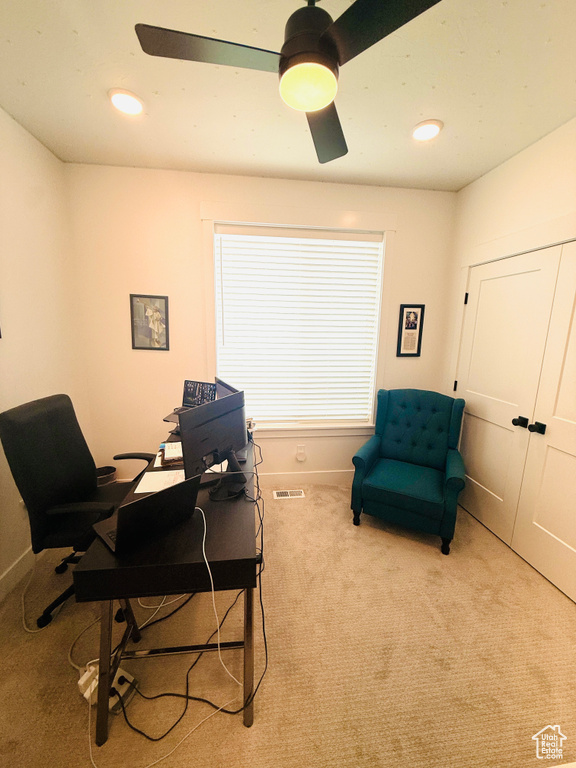 Home office featuring ceiling fan and carpet