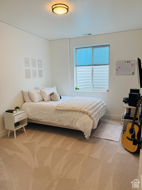 Bedroom featuring light carpet and baseboards