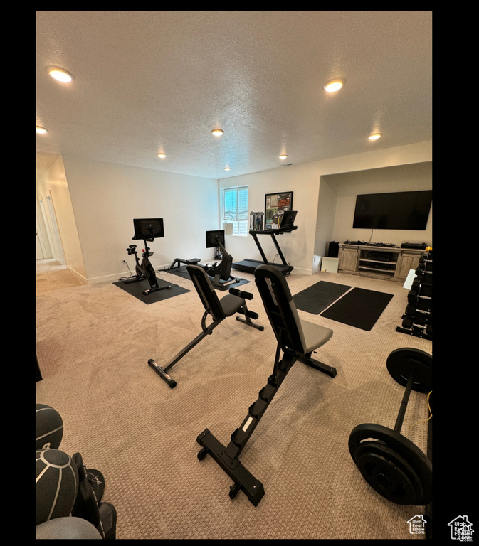 Workout area with carpet floors, recessed lighting, and a textured ceiling