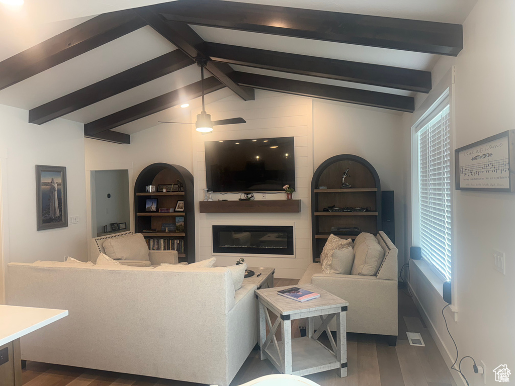 Living area featuring wood finished floors, a glass covered fireplace, and plenty of natural light