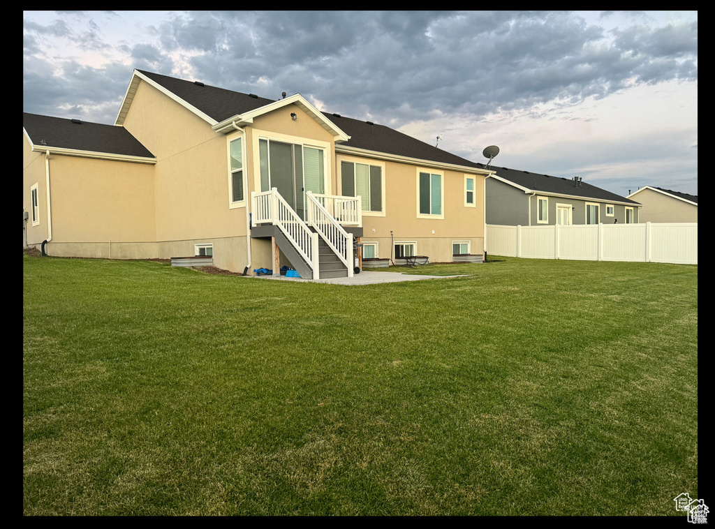 Back of property with stucco siding and a patio