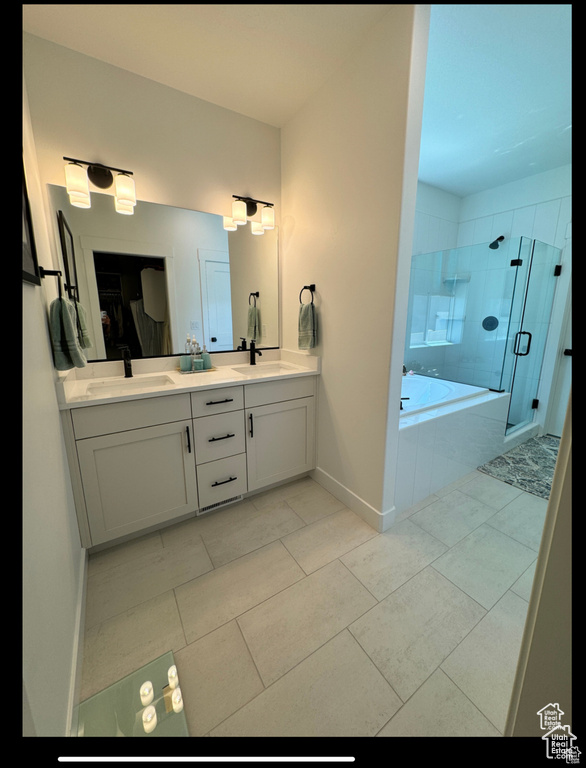 Full bath with double vanity, a garden tub, a shower stall, and tile patterned floors