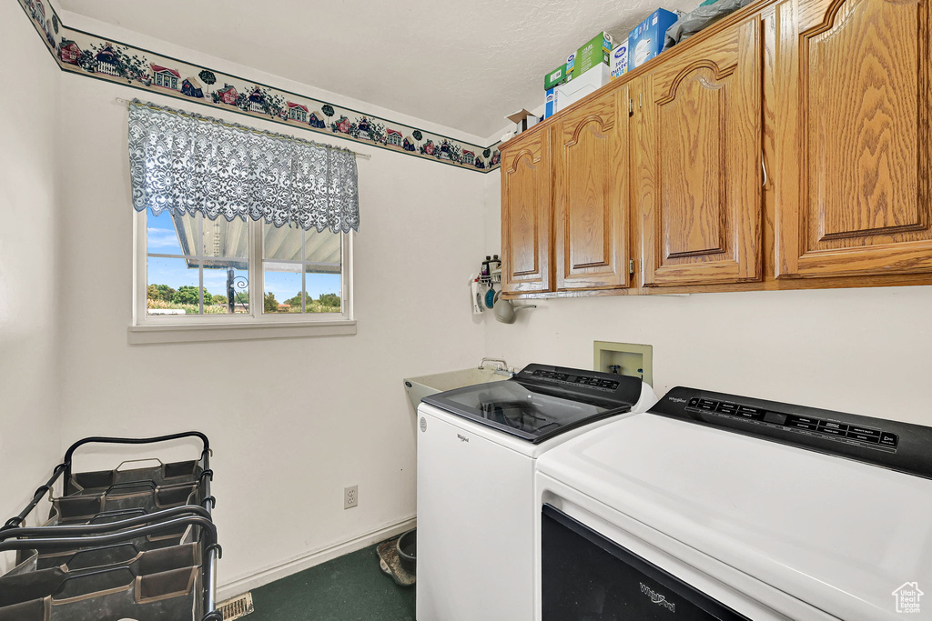 Washroom with cabinet space, washing machine and clothes dryer, and carpet