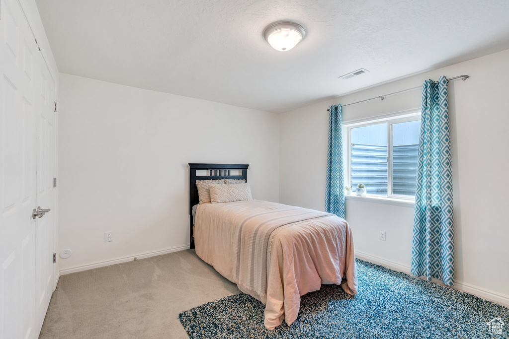 Bedroom featuring light colored carpet and baseboards