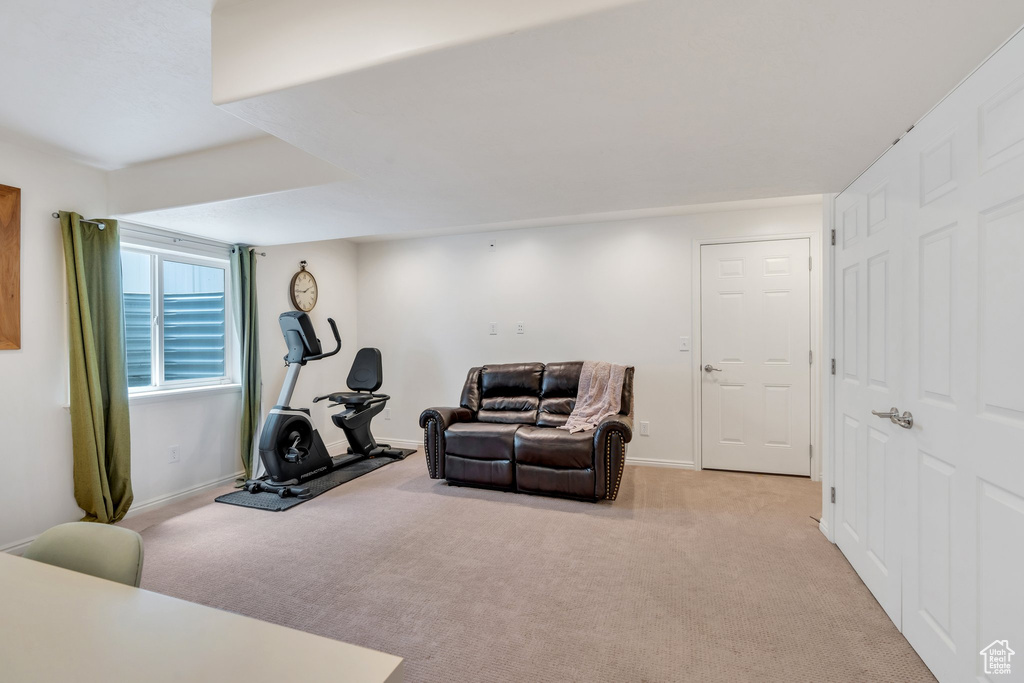 Exercise room with light colored carpet and baseboards