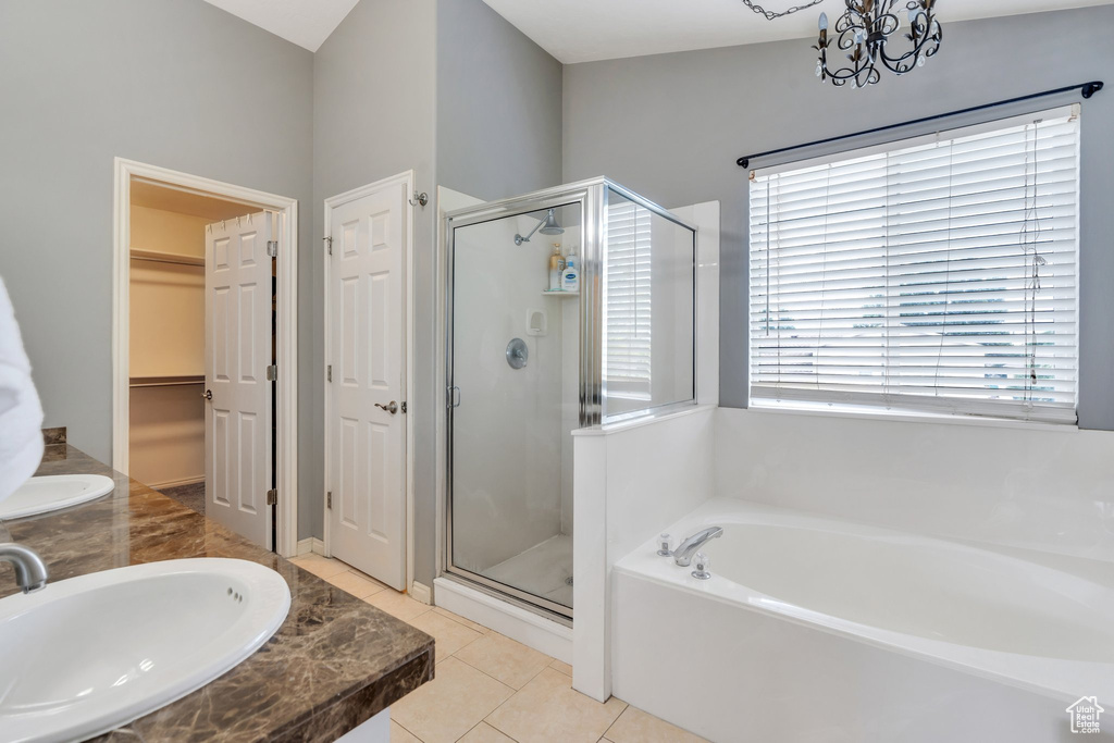 Full bath featuring a shower stall, a garden tub, a chandelier, and tile patterned floors