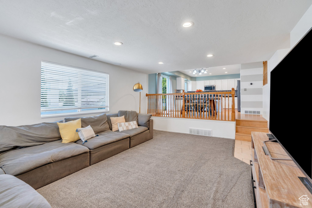 Living room featuring recessed lighting, light colored carpet, and a textured ceiling