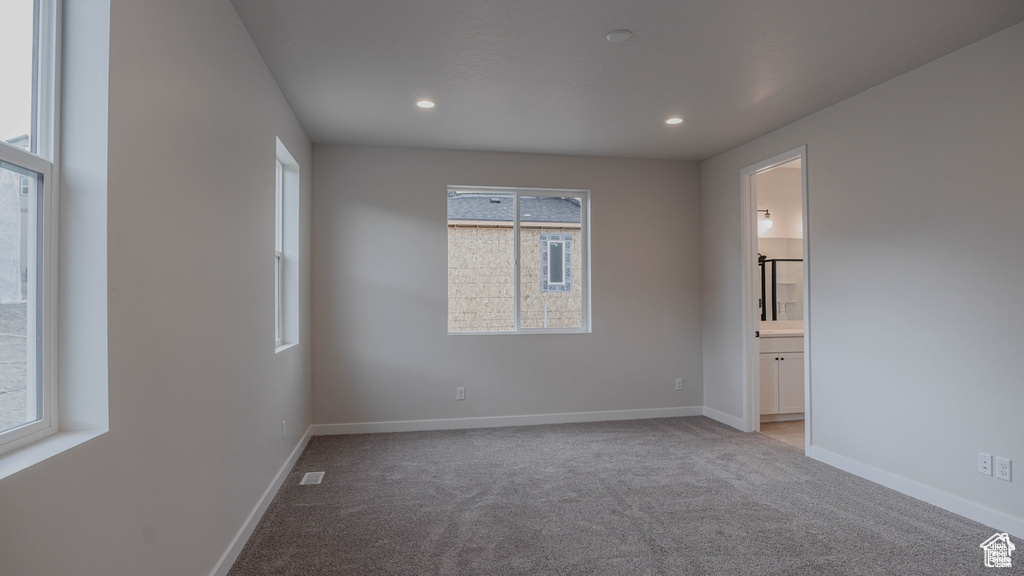 Empty room featuring light carpet, plenty of natural light, and recessed lighting