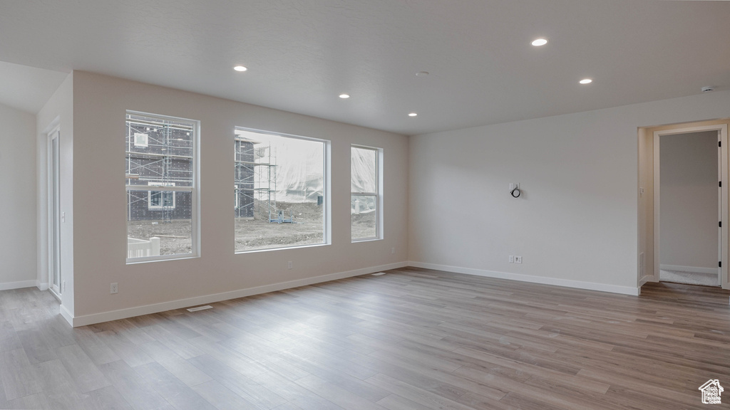 Empty room with light wood-type flooring and recessed lighting
