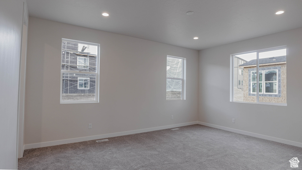 Carpeted empty room featuring baseboards and recessed lighting