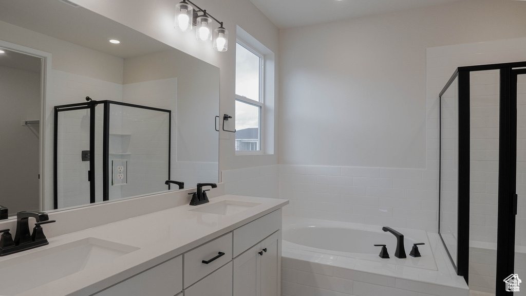Bathroom featuring a garden tub, a stall shower, double vanity, and recessed lighting