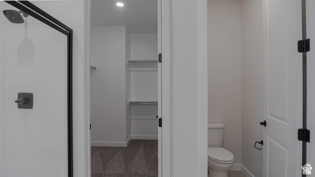 Bathroom featuring a shower stall and a spacious closet