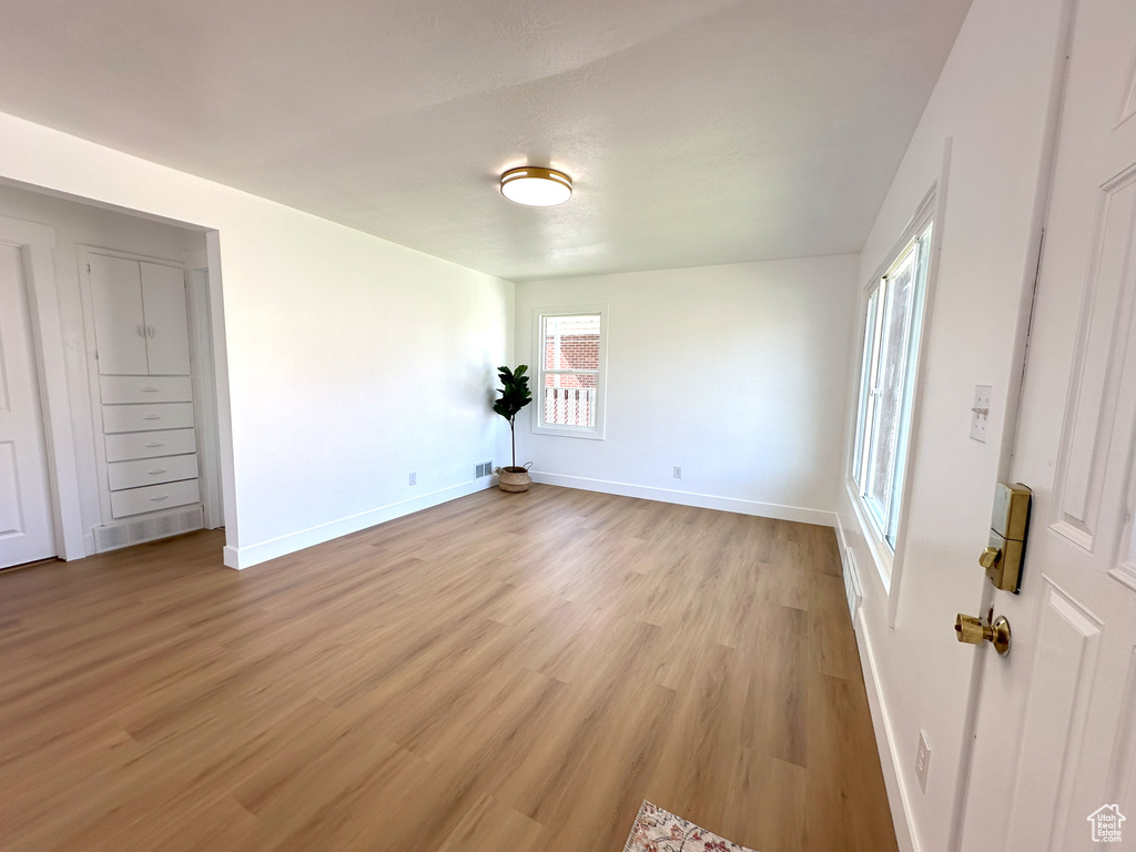 Spare room with baseboards and light wood-type flooring
