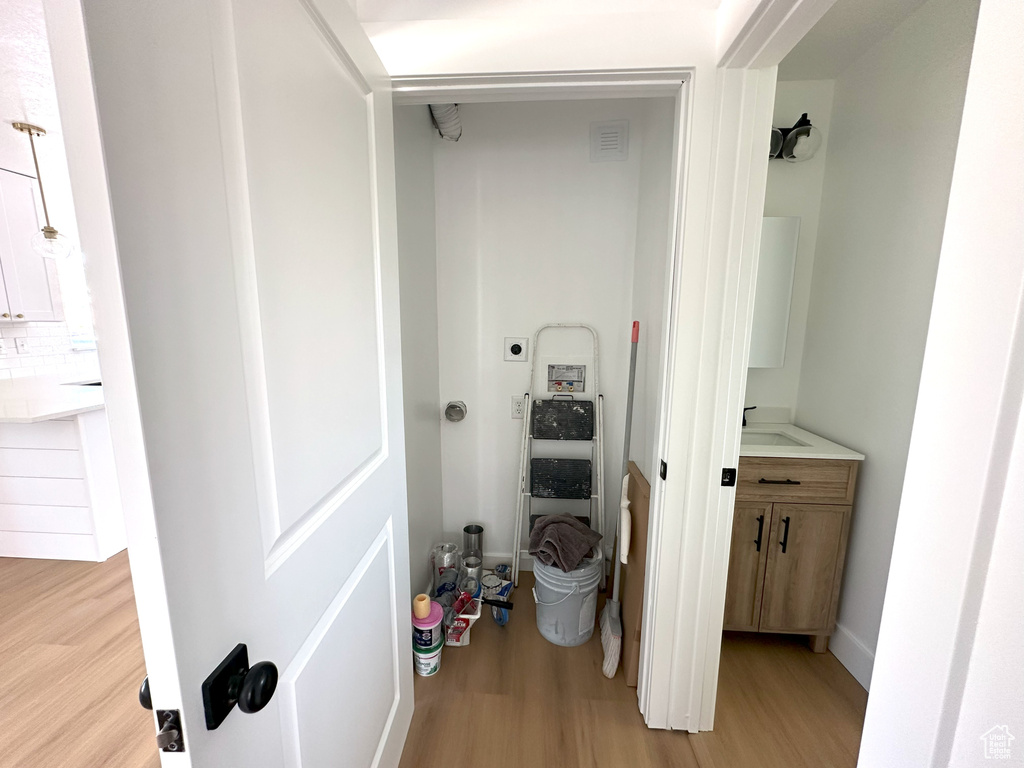 Hall with light wood-style flooring and a sink