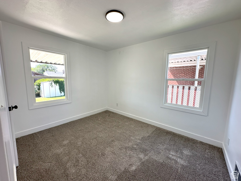 Unfurnished room featuring healthy amount of natural light and carpet flooring