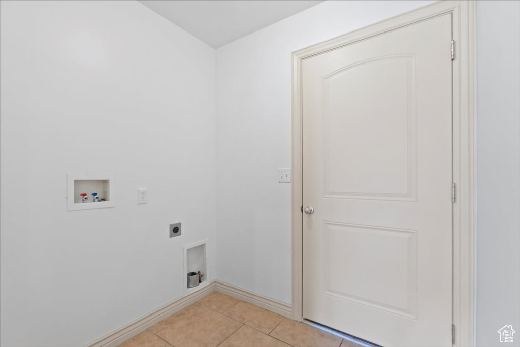 Washroom with hookup for an electric dryer, washer hookup, and light tile patterned flooring