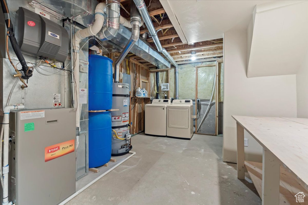 Unfinished basement with separate washer and dryer, water heater, and heating unit