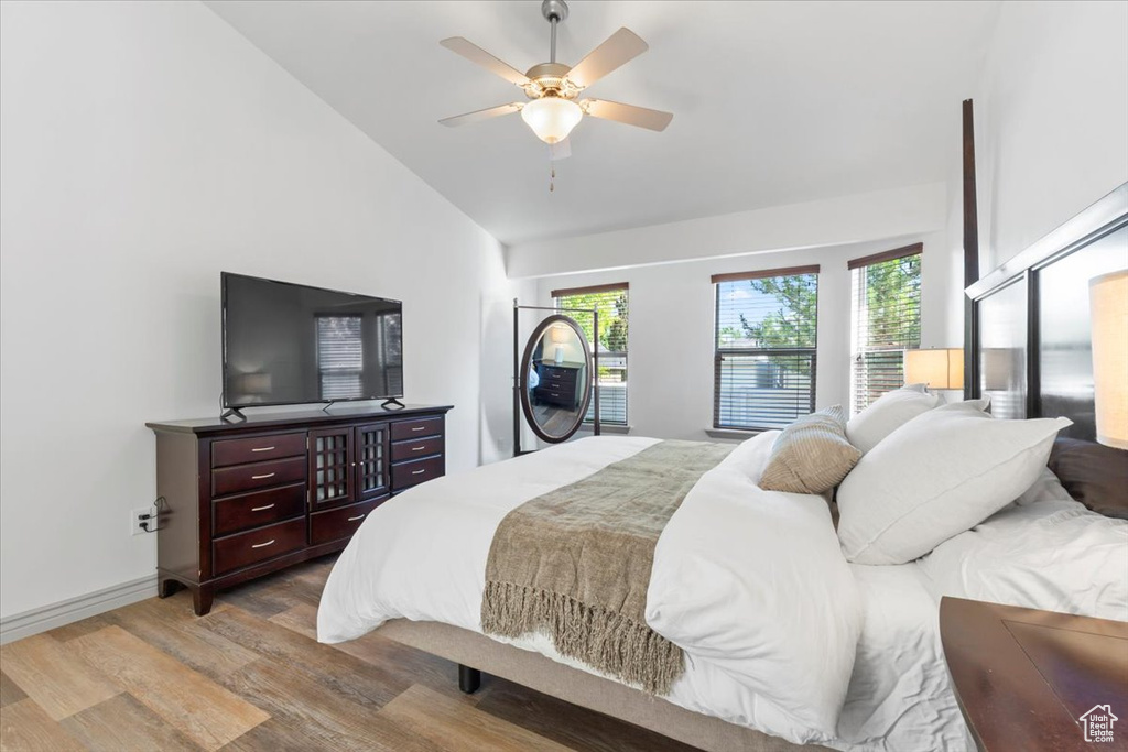 Bedroom featuring wood finished floors, high vaulted ceiling, and a ceiling fan