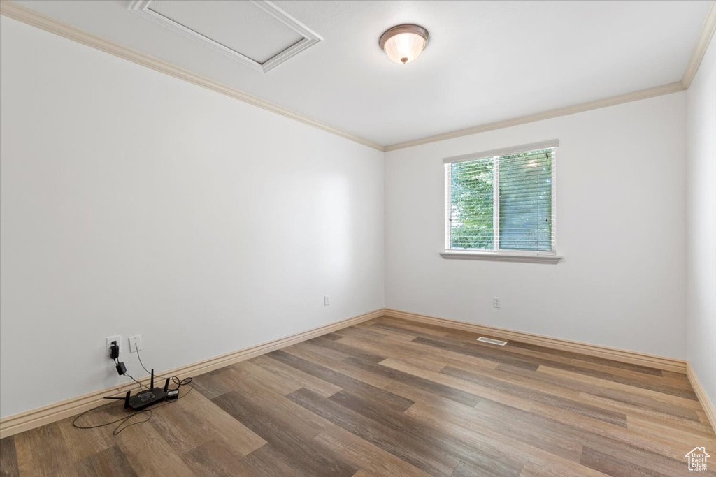 Unfurnished room featuring ornamental molding and wood finished floors