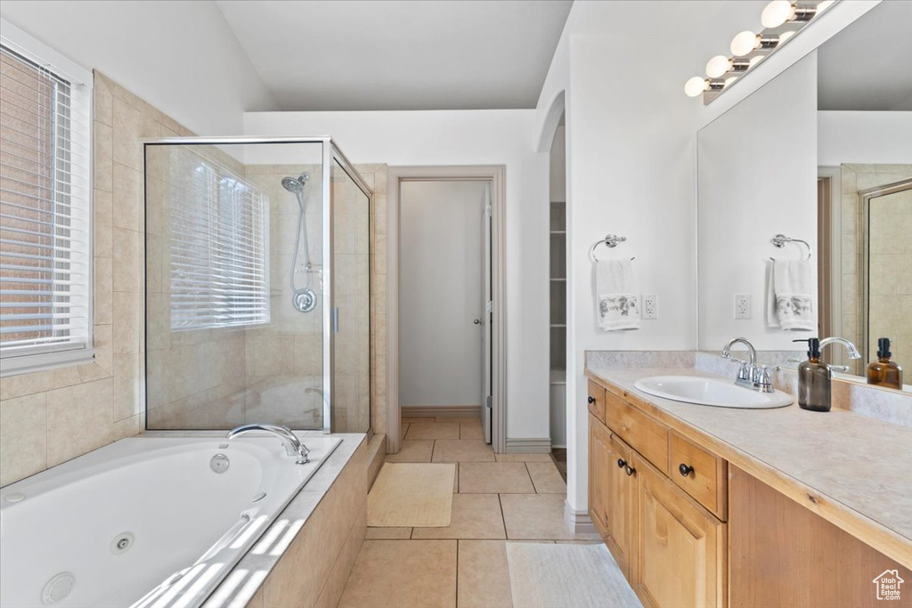 Bathroom with a stall shower, a whirlpool tub, vanity, and tile patterned flooring