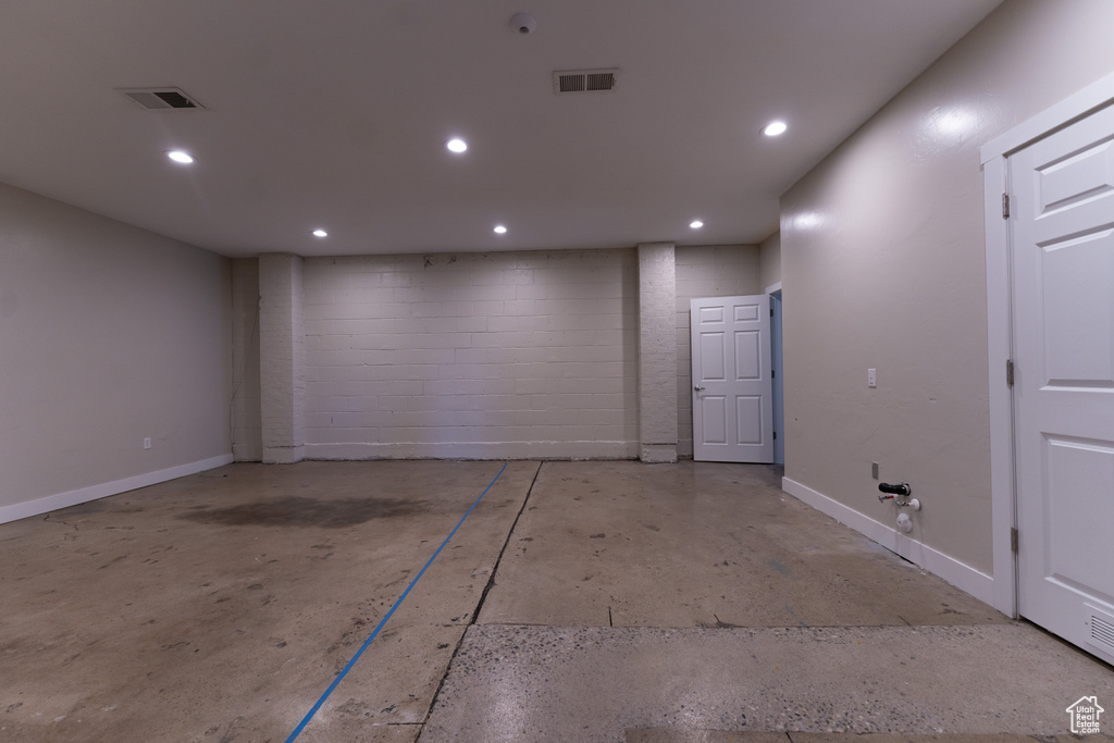 Garage featuring concrete block wall and recessed lighting