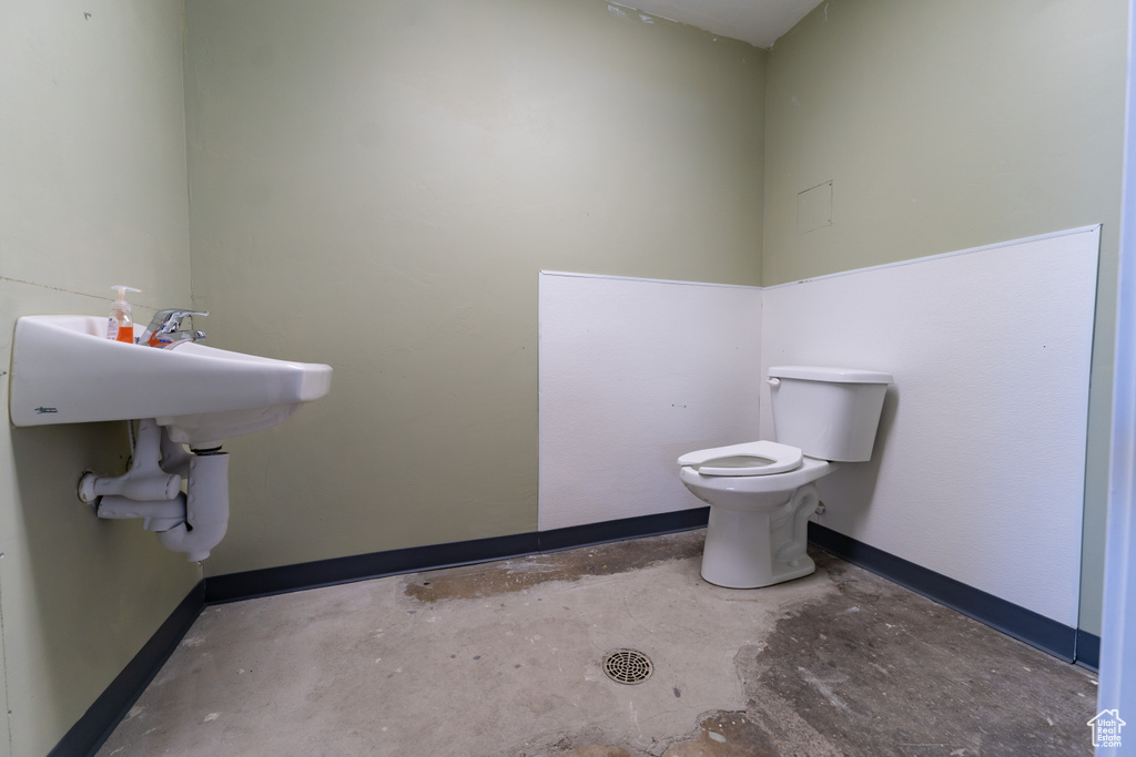 Half bath with concrete flooring and toilet