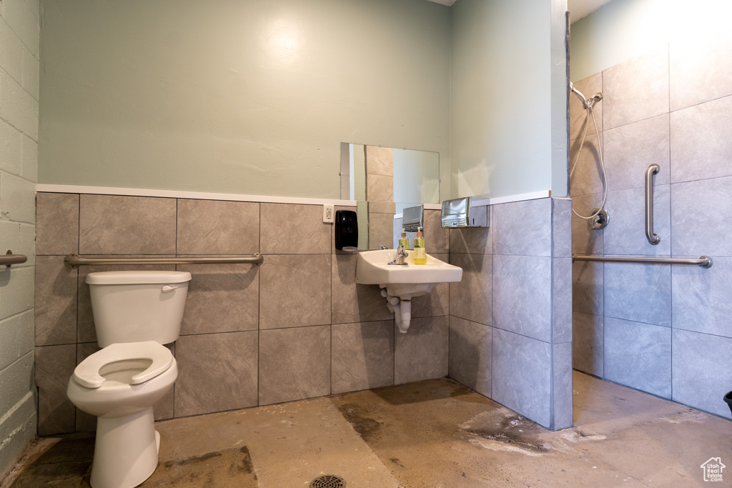 Full bathroom with tile walls, wainscoting, and a shower