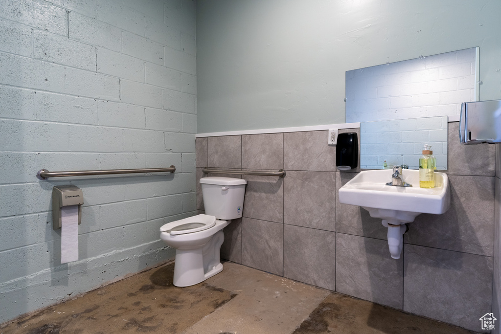 Half bathroom featuring concrete flooring and toilet