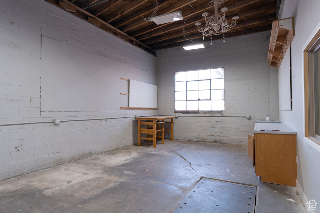 Misc room with concrete flooring and a chandelier