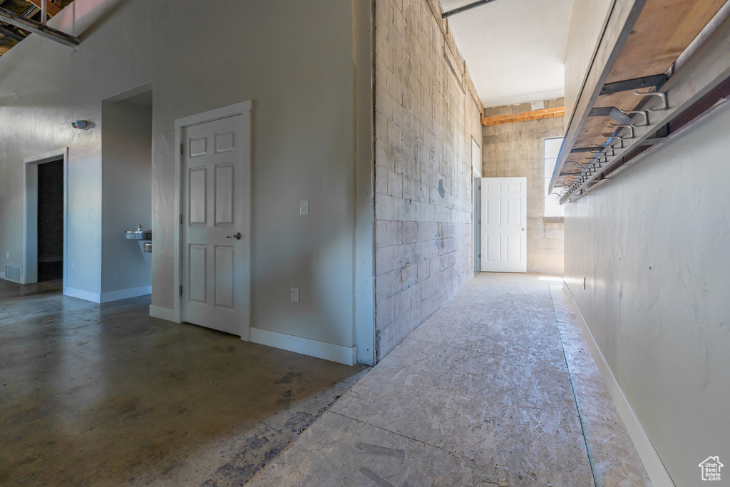 Hall featuring concrete flooring and a towering ceiling