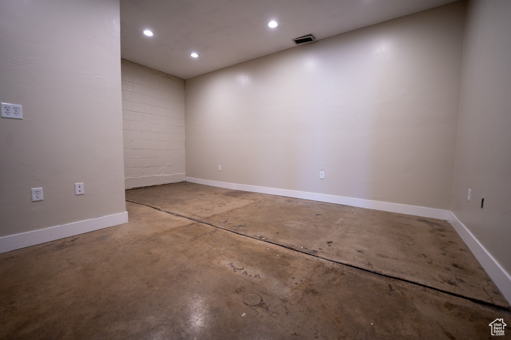 Spare room with concrete flooring and recessed lighting