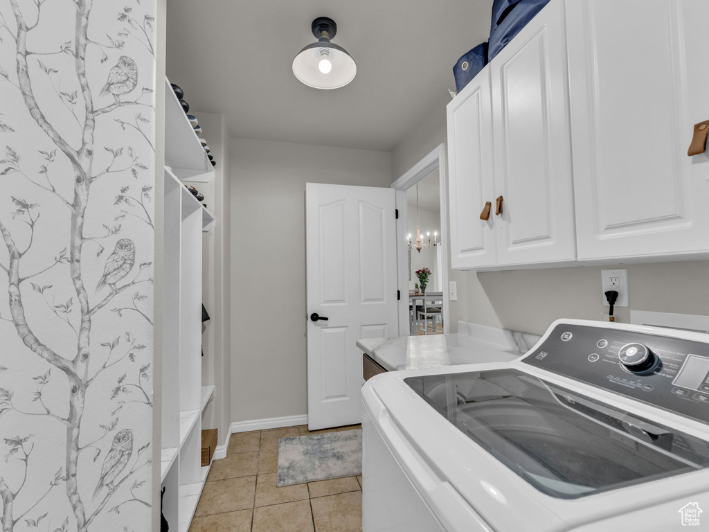 Laundry area with washer / dryer, cabinet space, and light tile patterned flooring