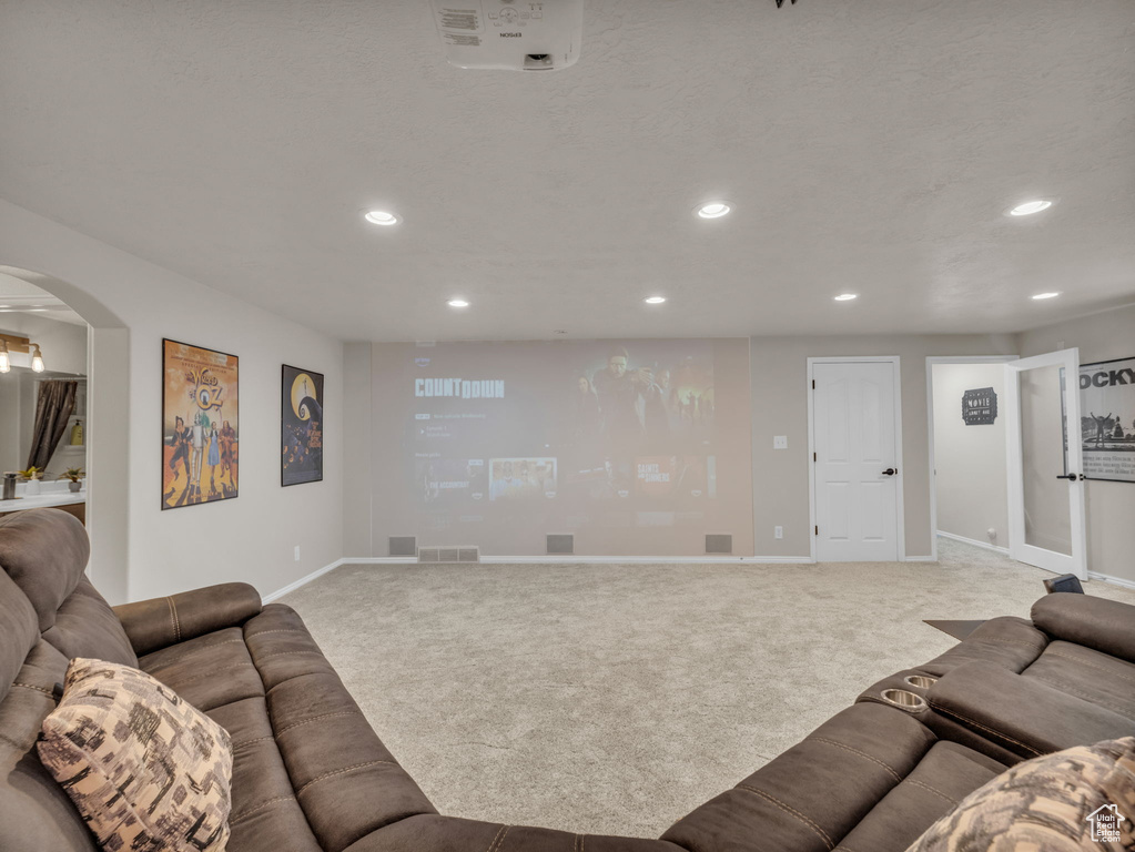Living room with carpet, recessed lighting, and arched walkways